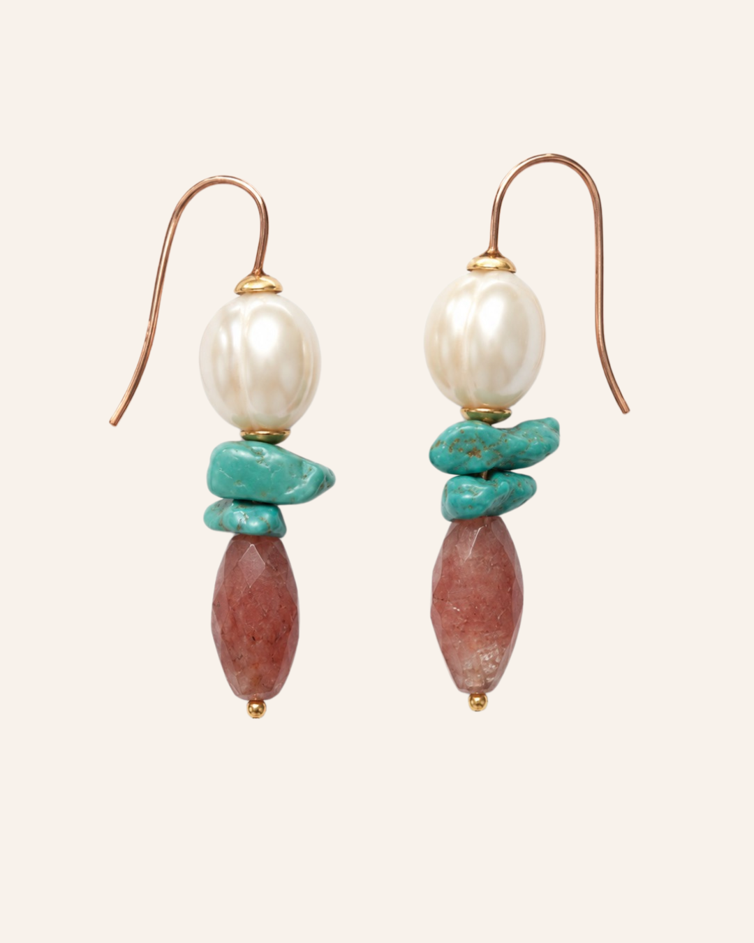 A pair of bohemian-style dangle earrings featuring a white baroque pearl, turquoise chips, and a reddish-brown stone bead, suspended from gold hooks on a light beige background.