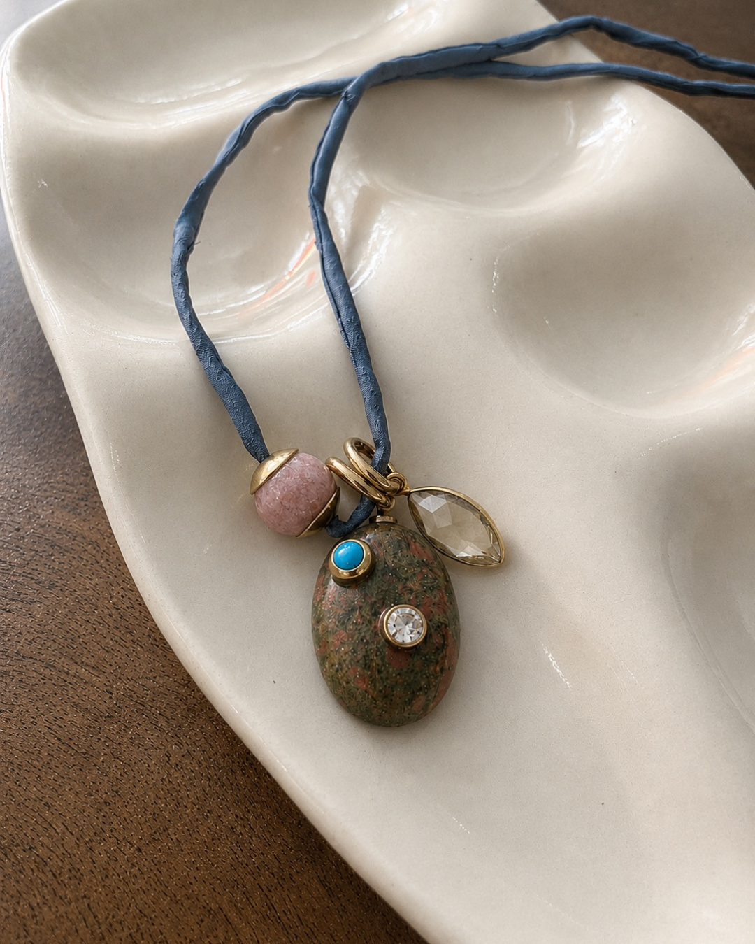 Necklace with a pendant on a white ceramic dish