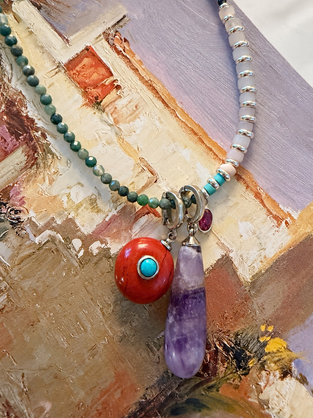 Sola Relic styled with another Relic on a gemstone strand against abstract artwork