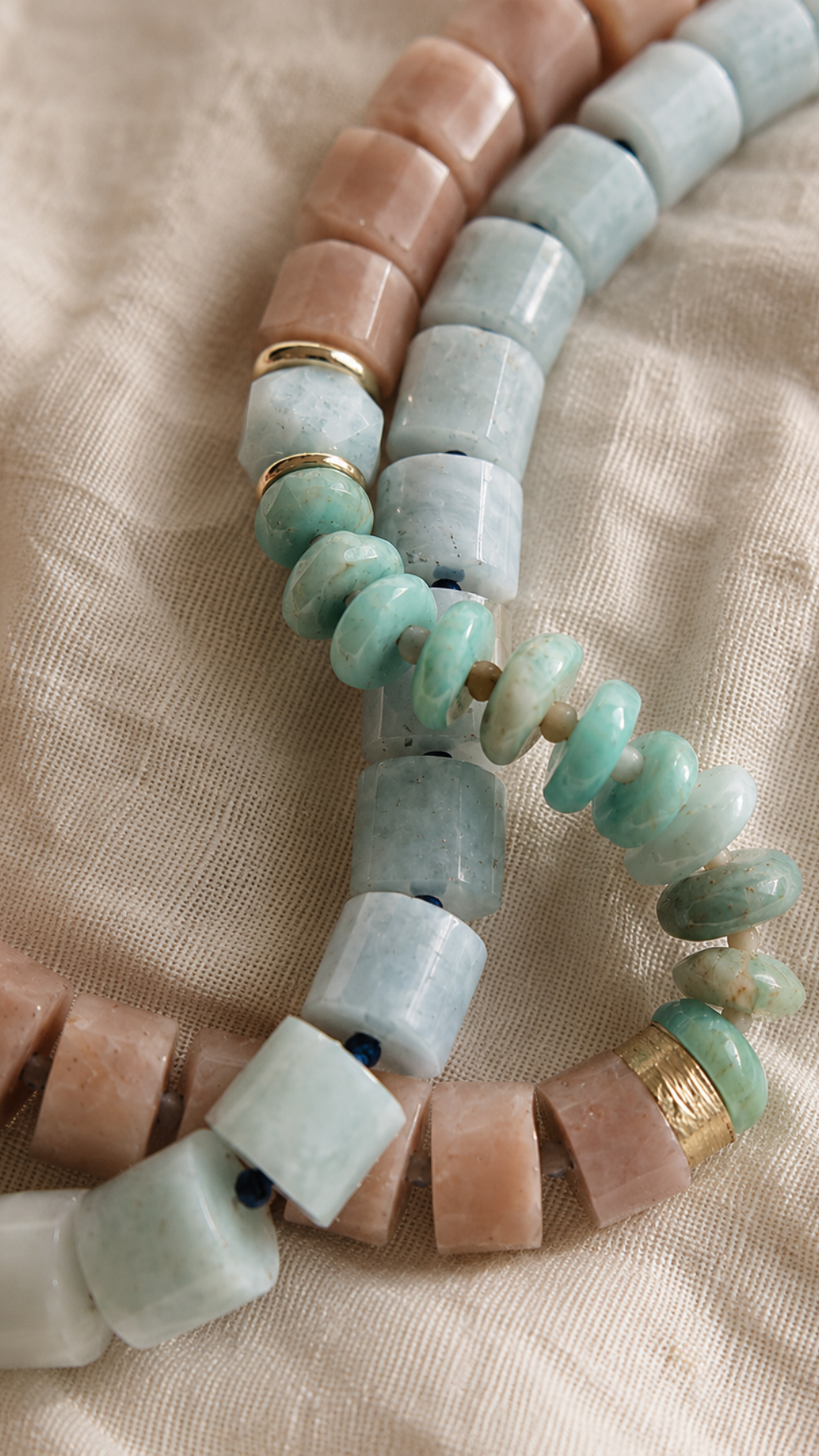 close up of two beaded necklaces on linen