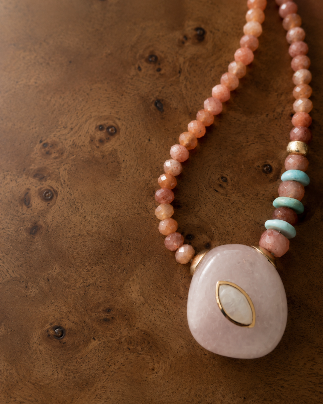close up of pink amethyst penant with rainbow moonstone on a sunstone and amazonite beaded necklace
