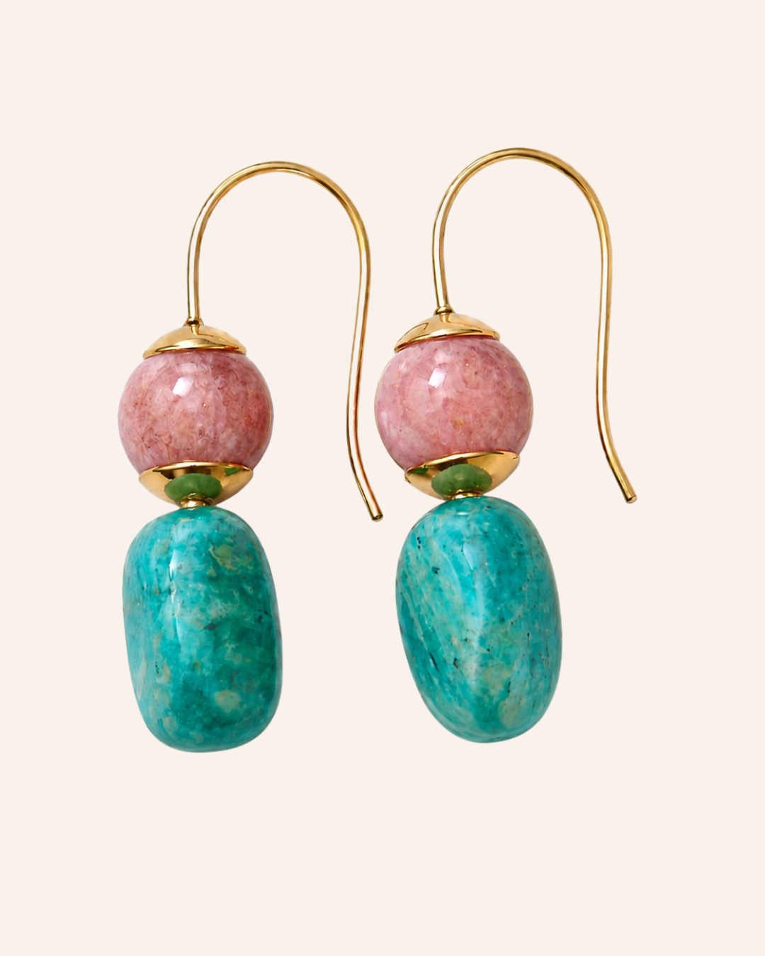 A pair of dangle earrings with gold-tone hooks, a round pink stone bead, and an elongated turquoise-blue stone bead, shown on a light cream background.