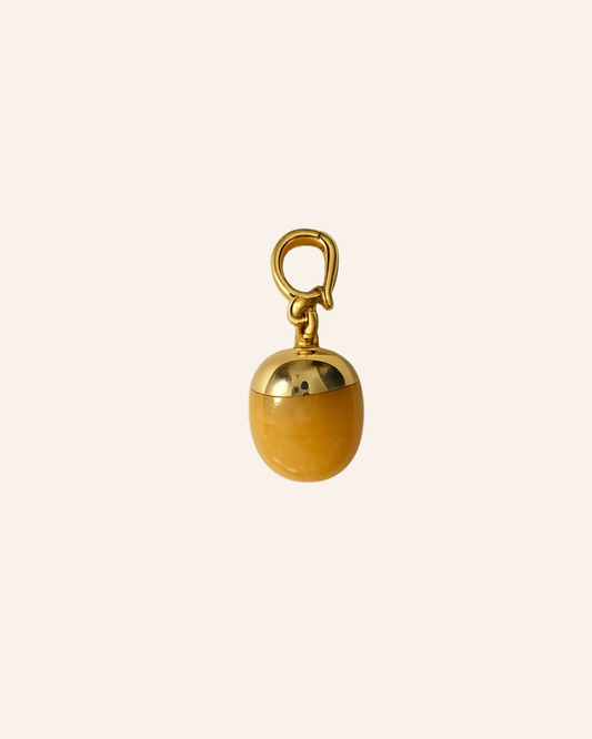 Yellow Orb stone with gold findings on an ivory background 