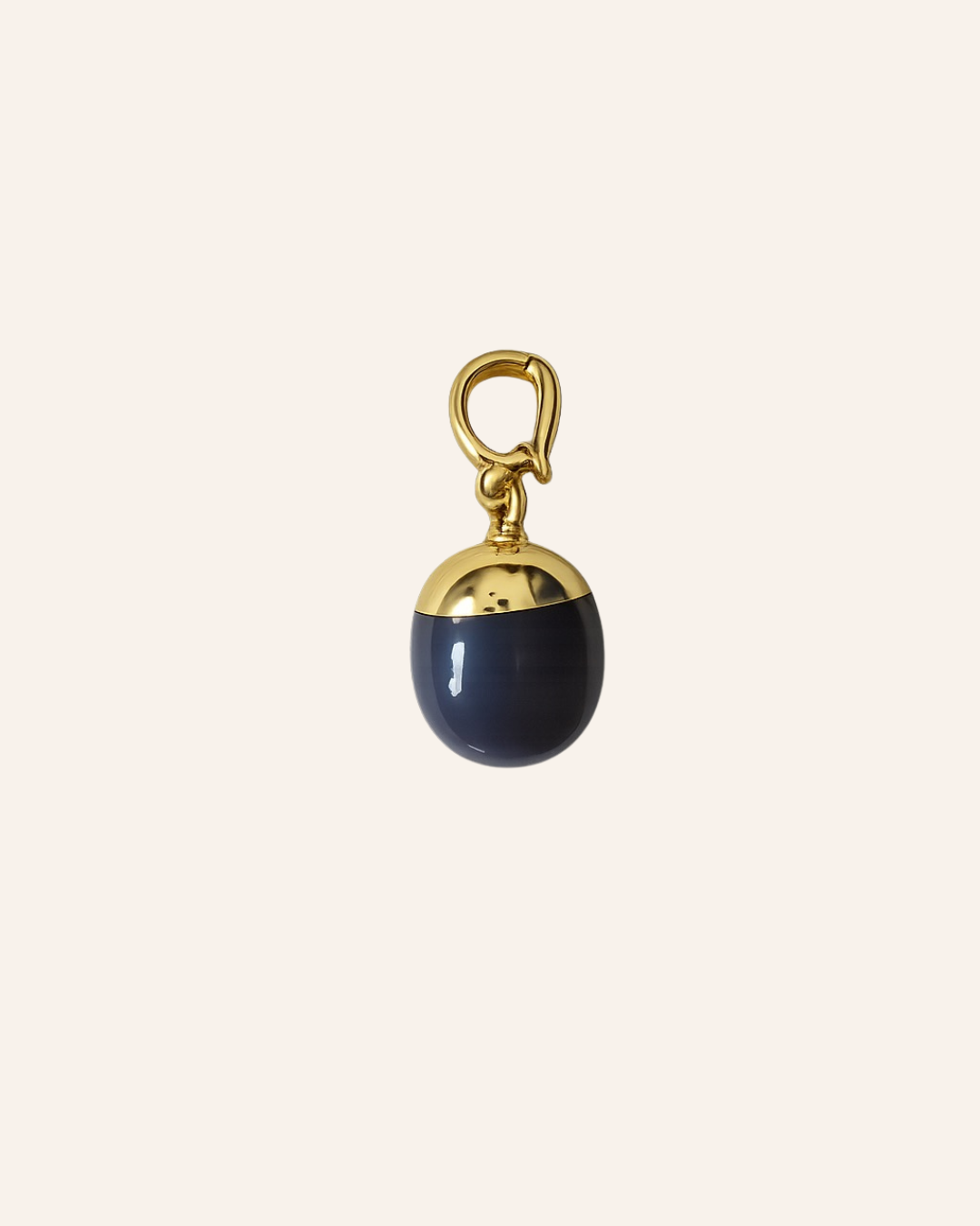 A small acorn-shaped charm with a glossy dark navy blue body and a polished gold-tone cap and loop, centered on a light cream background.
