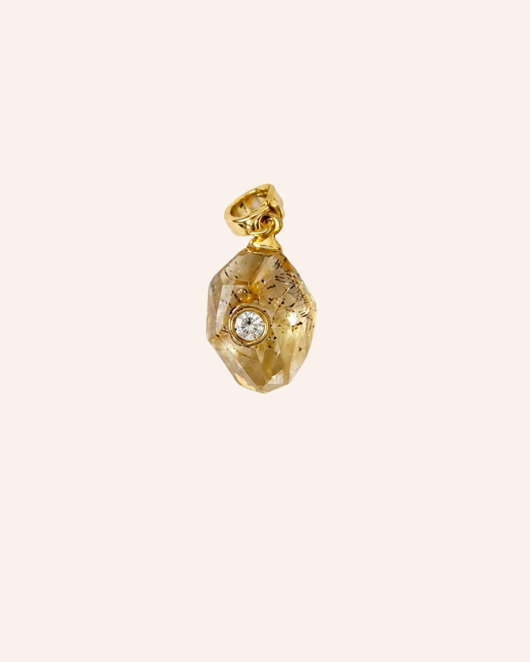 A gold pendant shaped like a faceted gemstone with a small clear round stone set in the center, shown on a plain light beige background.