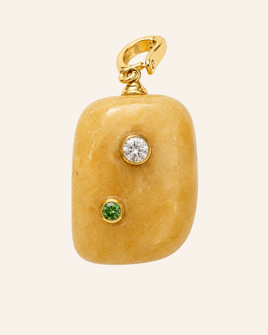 Calcite pendant with a moissanite and peridot on a cream background 
