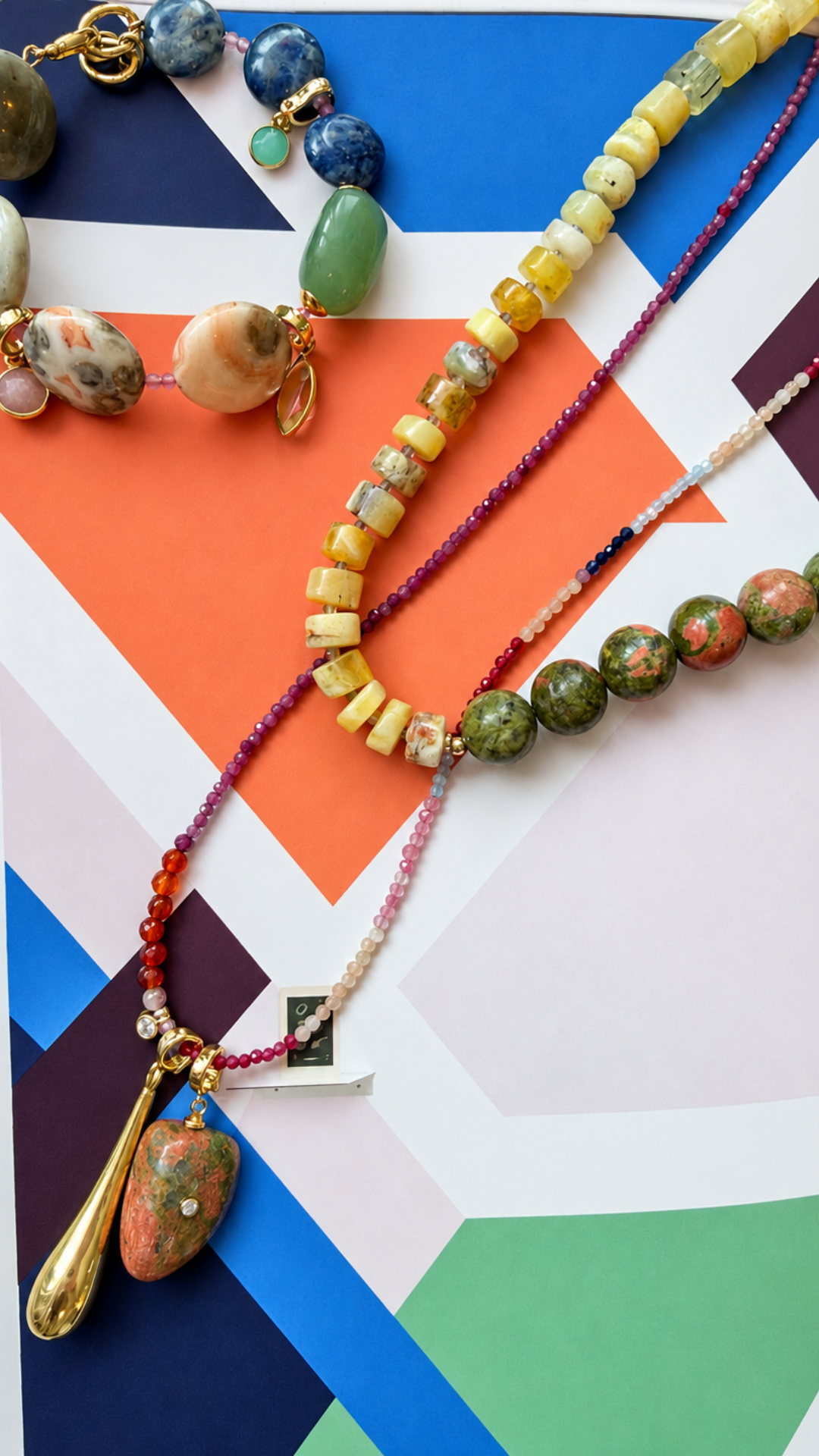 Mara Relic on a colorful gemstone strand against geometric artwork