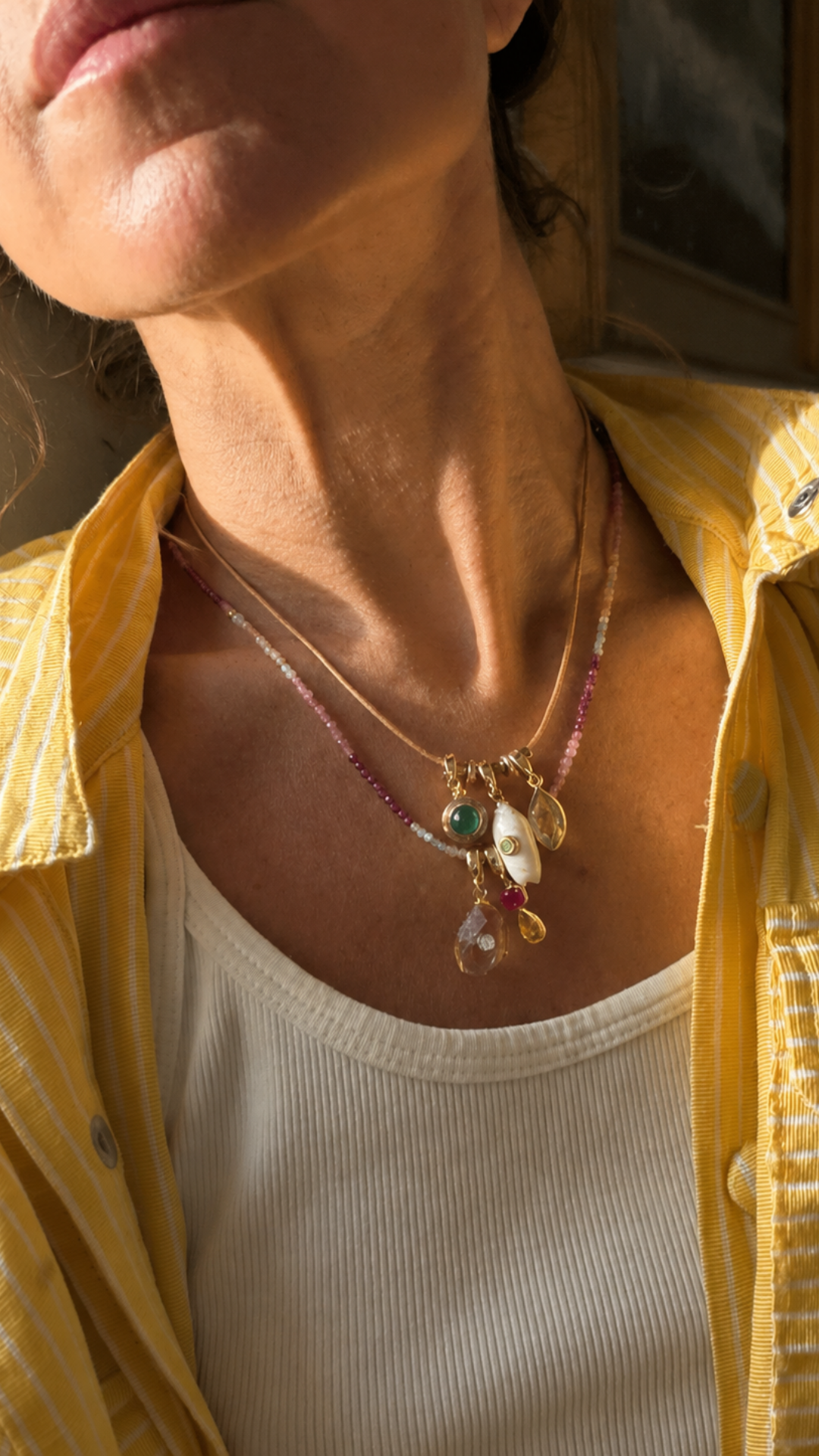Multiple Port Scarlett gemstone Relics on a fine necklace, layered with a colorful beaded strand