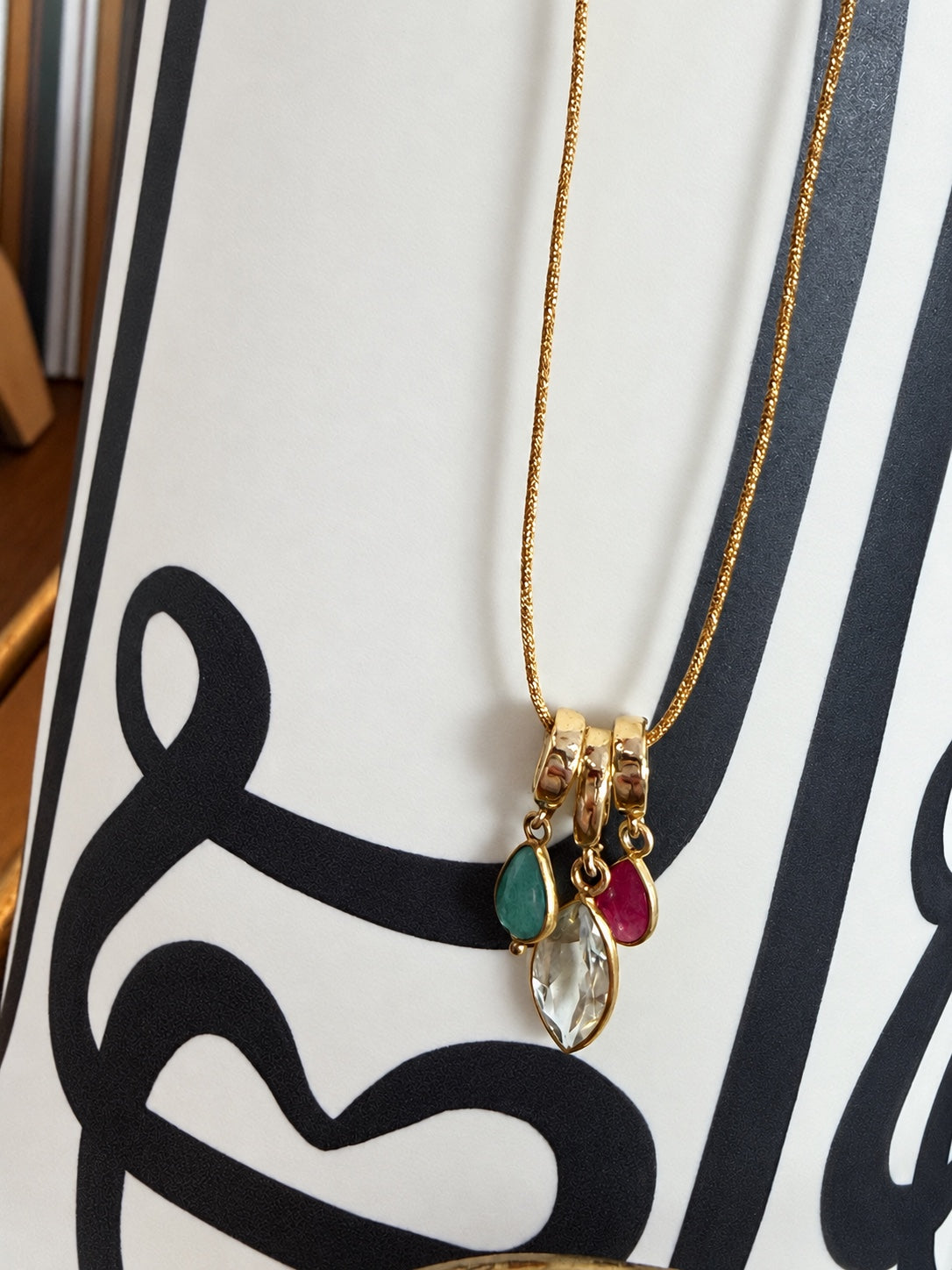 Vera emerald Relic styled with other small Relics on a gold chain